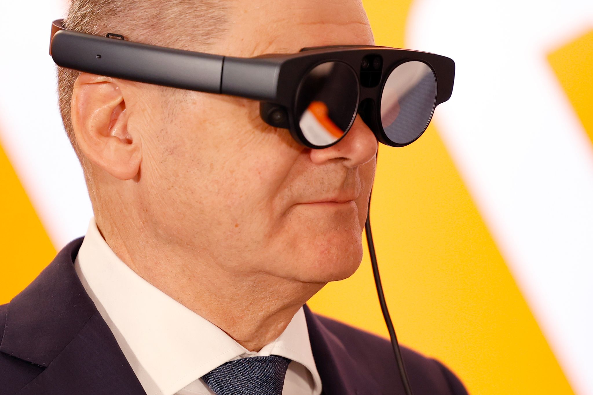 Bundeskanzler Olaf Scholz mit eier AR-Datenbrille (Augmented Reality) zur Prozessüberwachung einer Maschine. Foto: Michael Matthey/dpa